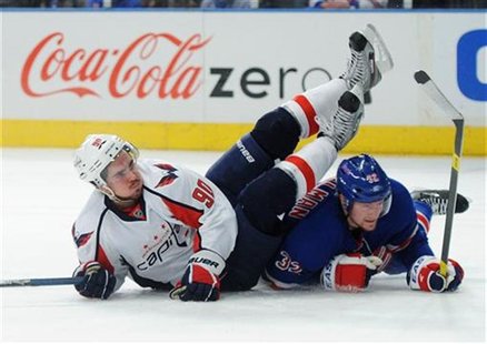 Washington Capitals' Marcus Johansson (L) is knocked to the ice by a sliding New York Rangers' Anton Stralman in the second period during Ga Washington Capitals' Marcus Johansson (L) is knocked to the ice by a sliding New York Rangers' Anton Stralman in the second period during Ga