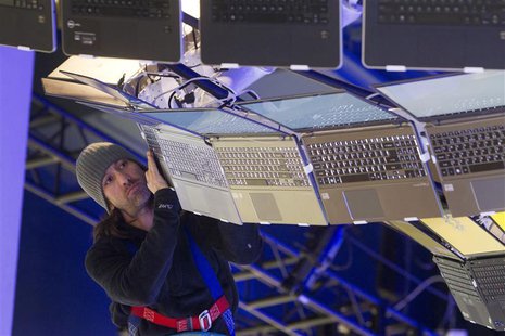 Rigger Matt Gerbracht arranges a display of Ultrabooks powered with Intel processors as workers prepare for the International CES show at th Rigger Matt Gerbracht arranges a display of Ultrabooks powered with Intel processors as workers prepare for the International CES show at th
