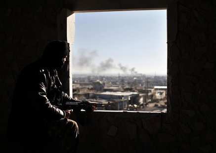A Free Syria Army fighter watches from his position during a fight with forces loyal to President Bashar al Assad at the front line in Alepp A Free Syria Army fighter watches from his position during a fight with forces loyal to President Bashar al Assad at the front line in Alepp