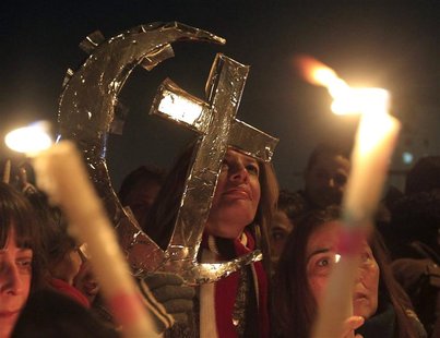 Egyptian Muslims and Christians celebrate Coptic Christmas eve mass at Tahrir Square in Cairo January 6, 2013. With the economic downturn an Egyptian Muslims and Christians celebrate Coptic Christmas eve mass at Tahrir Square in Cairo January 6, 2013. With the economic downturn an