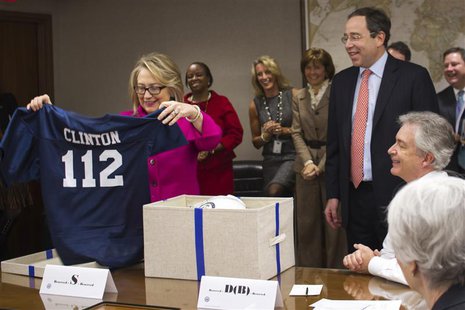 U.S. Secretary of State Hillary Clinton holds up a football jersey with her name on it, presented by Deputy Secretary of State Thomas Nides U.S. Secretary of State Hillary Clinton holds up a football jersey with her name on it, presented by Deputy Secretary of State Thomas Nides