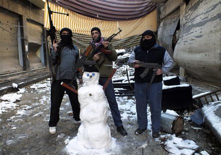 Members of the Free Syrian Army pose with their weapons and a snowman at the Jouret al Shayah area in Homs January 10, 2013. Picture taken J Members of the Free Syrian Army pose with their weapons and a snowman at the Jouret al Shayah area in Homs January 10, 2013. Picture taken J