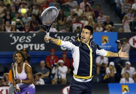 Novak Djokovic of Serbia hits a return as Serena Williams of the U.S. looks on during Kids Tennis Day at the Australian Open tennis tourname Novak Djokovic of Serbia hits a return as Serena Williams of the U.S. looks on during Kids Tennis Day at the Australian Open tennis tourname