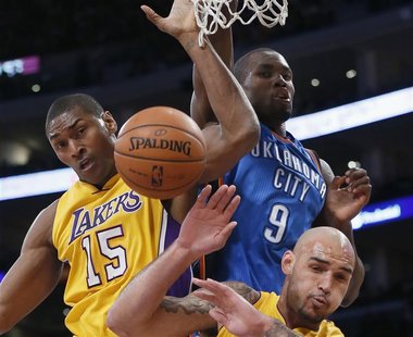 Oklahoma City Thunder's Serge Ibaka (C) fights for a rebound with Los Angeles Lakers Metta World Peace (L) and Robert Sacre of Canada during Oklahoma City Thunder's Serge Ibaka (C) fights for a rebound with Los Angeles Lakers Metta World Peace (L) and Robert Sacre of Canada during