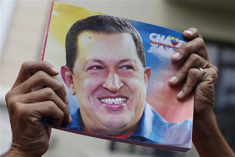 A supporter of Venezuela's President Hugo Chavez holds up a picture of him during the inauguration of the National Assembly in Caracas Janua A supporter of Venezuela's President Hugo Chavez holds up a picture of him during the inauguration of the National Assembly in Caracas Janua