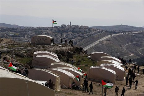 Palestinians, together with Israeli and foreign activists, stand near newly-erected tents in an area known as E1, near Jerusalem January 12, Palestinians, together with Israeli and foreign activists, stand near newly-erected tents in an area known as E1, near Jerusalem January 12,