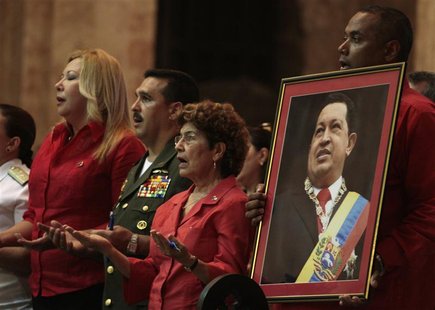 A Venezuelan man holds a picture of Venezuela's President Hugo Chavez during a mass to pray for his recovery at a church in Havana January 1 A Venezuelan man holds a picture of Venezuela's President Hugo Chavez during a mass to pray for his recovery at a church in Havana January 1