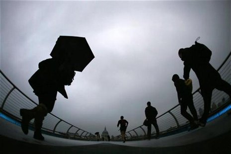 Commuters cross the Millenium Bridge during a rainy morning, towards the financial district the City of London November 27, 2012. REUTERS/St Commuters cross the Millenium Bridge during a rainy morning, towards the financial district the City of London November 27, 2012. REUTERS/St