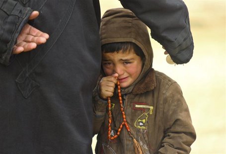 A boy, standing next to his father, cries as they wait to receive humanitarian aid in the countryside of Idlib January 13, 2013. Picture tak A boy, standing next to his father, cries as they wait to receive humanitarian aid in the countryside of Idlib January 13, 2013. Picture tak