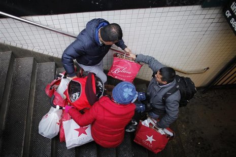 Shoppers go down the stairs with some bags and a stroller after their making purchases in New York, December 26, 2012. The 2012 holiday seas Shoppers go down the stairs with some bags and a stroller after their making purchases in New York, December 26, 2012. The 2012 holiday seas