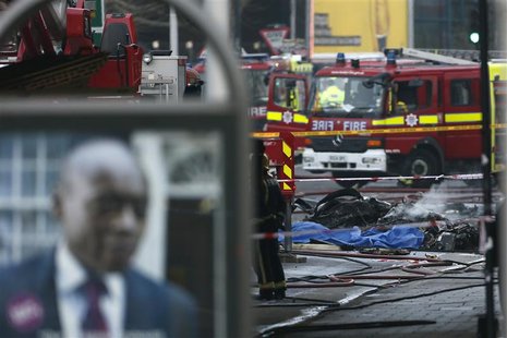 Smoke rises from debris as police and emergency services attend the scene of a helicopter crash in Vauxhall, south London January 16, 2013. Smoke rises from debris as police and emergency services attend the scene of a helicopter crash in Vauxhall, south London January 16, 2013.