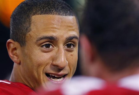 San Francisco quarterback Colin Kaepernick talks to a teammate on the bench in the fourth quarter during their NFL NFC Divisional playoff fo San Francisco quarterback Colin Kaepernick talks to a teammate on the bench in the fourth quarter during their NFL NFC Divisional playoff fo