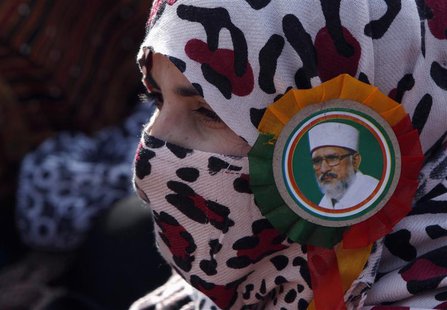 A supporter of Sufi cleric and leader of the Minhaj-ul-Quran religious organisation Muhammad Tahirul Qadri wears her leader's badge on her s A supporter of Sufi cleric and leader of the Minhaj-ul-Quran religious organisation Muhammad Tahirul Qadri wears her leader's badge on her s