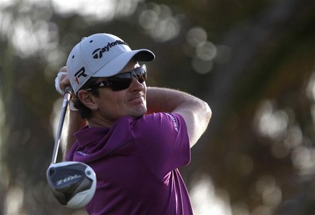 Justin Rose of England watches his shot from the 18th tee during the first round of the Abu Dhabi Golf Championship at the Abu Dhabi Golf Cl Justin Rose of England watches his shot from the 18th tee during the first round of the Abu Dhabi Golf Championship at the Abu Dhabi Golf Cl