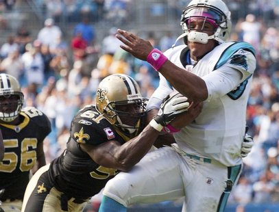 Carolina Panthers' quarterback Cam Newton (R) is hit by New Orleans Saints' middle linebacker Jonathan Vilma during an NFL football game in Carolina Panthers' quarterback Cam Newton (R) is hit by New Orleans Saints' middle linebacker Jonathan Vilma during an NFL football game in