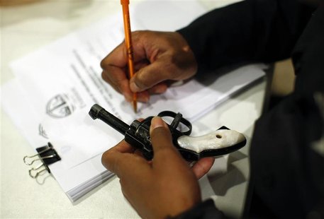 An Evanston police officer documents some information on a firearm that was turned in as part of an amnesty-based gun buyback program in Eva An Evanston police officer documents some information on a firearm that was turned in as part of an amnesty-based gun buyback program in Eva