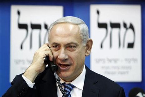 Israel's Prime Minister Benjamin Netanyahu (C) speaks on the phone to persuade citizens to vote for his party at the Likud-Yisrael Beitenu h Israel's Prime Minister Benjamin Netanyahu (C) speaks on the phone to persuade citizens to vote for his party at the Likud-Yisrael Beitenu h