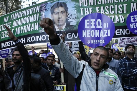 Immigrants raise their arms in front of a banner depicting late Pakistani immigrant Shehzad Luqman during an anti-racism rally in Athens Jan Immigrants raise their arms in front of a banner depicting late Pakistani immigrant Shehzad Luqman during an anti-racism rally in Athens Jan
