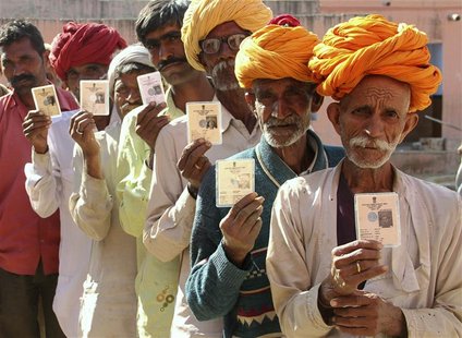 Villagers pose with their identity cards as they stand in line to open a bank account at a camp organised by a private bank in a village at Villagers pose with their identity cards as they stand in line to open a bank account at a camp organised by a private bank in a village at