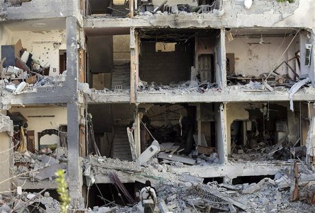 A fighter from the Free Syrian Army's Tahrir al Sham brigade looks at a building destroyed during yesterday's Syrian Air force air strike in A fighter from the Free Syrian Army's Tahrir al Sham brigade looks at a building destroyed during yesterday's Syrian Air force air strike in