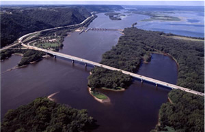View looking north as Interstate 90 crosses from La Crosse Wisconsin to Dresbach Minnesota on the left. Also visible, US Highway 61 interchange with I-90 on left and the Army Corps of Engineers Dresbach Lock and Dam on the Mississippi River's main channel. Photo courtesy MN DOT. View looking north as Interstate 90 crosses from La Crosse Wisconsin to Dresbach Minnesota on the left. Also visible, US Highway 61 interchange with I-90 on left and the Army Corps of Engineers Dresbach Lock and Dam on the Mississippi River's main channel. Photo courtesy MN DOT.