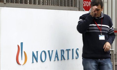 An employee smokes a cigarette beside the logo of Swiss drugmaker Novartis AG in front of a plant in Basel October 25, 2011. REUTERS/Arnd Wi An employee smokes a cigarette beside the logo of Swiss drugmaker Novartis AG in front of a plant in Basel October 25, 2011. REUTERS/Arnd Wi