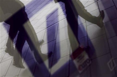 Pedestrians are reflected in a window as they walk in front of the headquarters of Deutsche Bank AG in Frankfurt September 5, 2011. REUTERS/ Pedestrians are reflected in a window as they walk in front of the headquarters of Deutsche Bank AG in Frankfurt September 5, 2011. REUTERS/