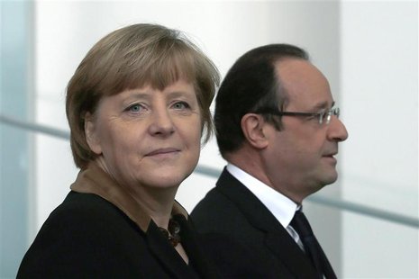 German Chancellor Angela Merkel (L) and French President Francois Hollande leave a family picture opportunity at the chancellery in Berlin d German Chancellor Angela Merkel (L) and French President Francois Hollande leave a family picture opportunity at the chancellery in Berlin d