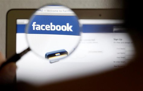 In this photo illustration, a Facebook logo on a computer screen is seen through a magnifying glass held by a woman in Bern May 19, 2012. Pi In this photo illustration, a Facebook logo on a computer screen is seen through a magnifying glass held by a woman in Bern May 19, 2012. Pi