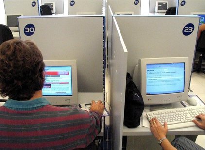 A foreigner (L) surfs the Internet at a modern Havana cybercafe as a Cuban customer gets an error message on her screen after attempting to A foreigner (L) surfs the Internet at a modern Havana cybercafe as a Cuban customer gets an error message on her screen after attempting to