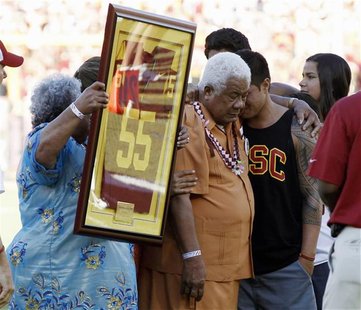Family members hold up a No. 55 jersey as part of a ceremony held in memory of the late former USC Trojans, San Diego Chargers and NFL lineb Family members hold up a No. 55 jersey as part of a ceremony held in memory of the late former USC Trojans, San Diego Chargers and NFL lineb