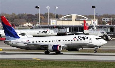 A Delta Air Lines jet takes off past a Northwest Airline jets parked at gates at the Minneapolis St.Paul International Airport in Minneapoli A Delta Air Lines jet takes off past a Northwest Airline jets parked at gates at the Minneapolis St.Paul International Airport in Minneapoli