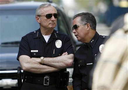 Los Angeles police chief William Bratton (L) stands next to an unidentified officer as people take part in a May Day protest march for immig Los Angeles police chief William Bratton (L) stands next to an unidentified officer as people take part in a May Day protest march for immig