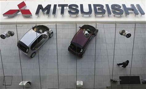 Mitsubishi Motors Corp's vehicles and a passer-by are reflected on an external wall at the company headquarters in Tokyo January 20, 2011. R Mitsubishi Motors Corp's vehicles and a passer-by are reflected on an external wall at the company headquarters in Tokyo January 20, 2011. R