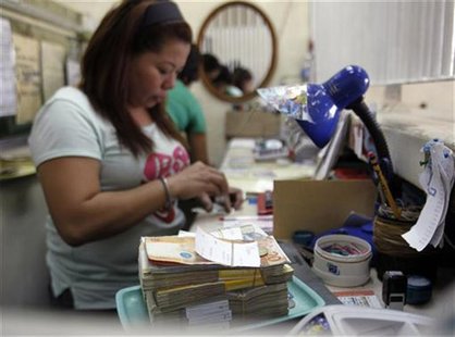 A woman counts peso bills at a currency exchange office in Manila September 26, 2012. REUTERS/Cheryl Ravelo A woman counts peso bills at a currency exchange office in Manila September 26, 2012. REUTERS/Cheryl Ravelo