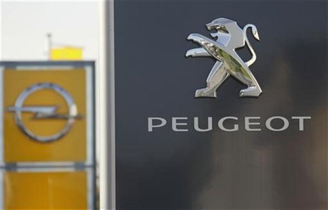 The logos of German General Motors daughter Opel and French car maker Peugeot are seen at a Opel and Peugeot dealership in Leverkusen near C The logos of German General Motors daughter Opel and French car maker Peugeot are seen at a Opel and Peugeot dealership in Leverkusen near C