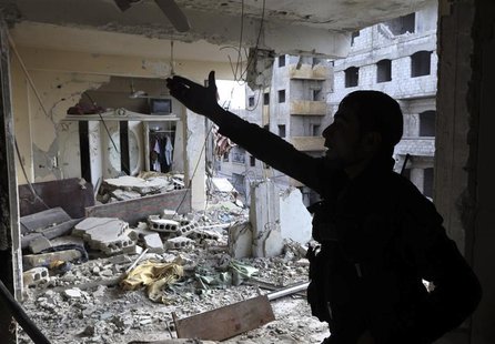 A Free Syrian Army fighter gestures in a building damaged by Syrian Army tank shells in the Arabeen neighbourhood of Damascus January 24, 20 A Free Syrian Army fighter gestures in a building damaged by Syrian Army tank shells in the Arabeen neighbourhood of Damascus January 24, 20