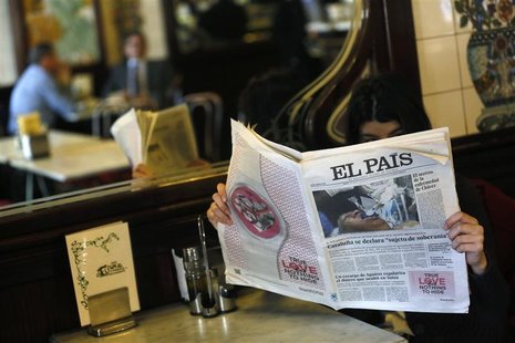 A woman poses with a copy of the January 24 first edition of Spanish newspaper El Pais in a cafe in central Madrid January 24, 2013. REUTERS A woman poses with a copy of the January 24 first edition of Spanish newspaper El Pais in a cafe in central Madrid January 24, 2013. REUTERS
