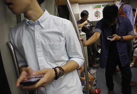 Commuters use their smartphones in a train in Singapore January 26, 2013. REUTERS/Edgar Su Commuters use their smartphones in a train in Singapore January 26, 2013. REUTERS/Edgar Su