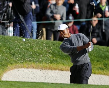 U.S. golfer Tiger Woods hits from a sand trap on the 18th green during weather delayed third round play at the Farmers Insurance Open in San U.S. golfer Tiger Woods hits from a sand trap on the 18th green during weather delayed third round play at the Farmers Insurance Open in San