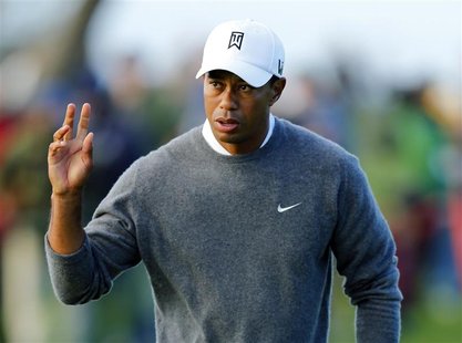 U.S. golfer Tiger Woods waves to fans after making par on the fifth hole during the weather-delayed fourth round play at the Farmers Insuran U.S. golfer Tiger Woods waves to fans after making par on the fifth hole during the weather-delayed fourth round play at the Farmers Insuran