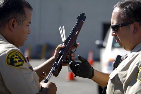 Los Angeles County Sheriff deputies take in guns from motorists trading them in at the 'Gifts for Guns' gun buyback in Compton, California, Los Angeles County Sheriff deputies take in guns from motorists trading them in at the 'Gifts for Guns' gun buyback in Compton, California,