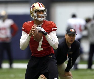 San Francisco 49ers quarterback Colin Kaepernick (L) throws a pass as head coach Jim Harbaugh (R) looks on during practice for the Super Bow San Francisco 49ers quarterback Colin Kaepernick (L) throws a pass as head coach Jim Harbaugh (R) looks on during practice for the Super Bow