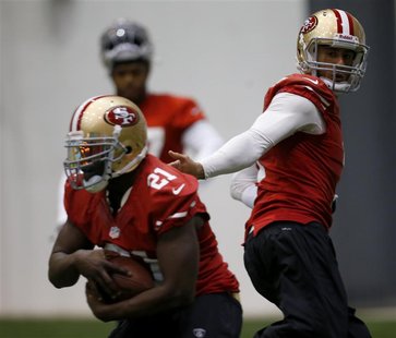 San Francisco 49ers quarterback Colin Kaepernick (R) hands off to running back Frank Gore (L) during practice for the Super Bowl in New Orle San Francisco 49ers quarterback Colin Kaepernick (R) hands off to running back Frank Gore (L) during practice for the Super Bowl in New Orle