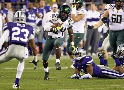 Oregon Ducks running back Kenjon Barner (24) runs past Kansas State Wildcats linebacker Arthur Brown (4) during the Fiesta Bowl football gam Oregon Ducks running back Kenjon Barner (24) runs past Kansas State Wildcats linebacker Arthur Brown (4) during the Fiesta Bowl football gam