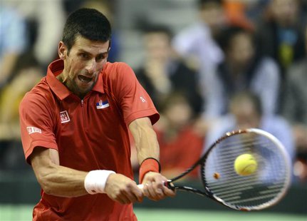 Novak Djokovic of Serbia returns the ball to Olivier Rochus of Belgium during their world group first round match in the Davis Cup tennis to Novak Djokovic of Serbia returns the ball to Olivier Rochus of Belgium during their world group first round match in the Davis Cup tennis to