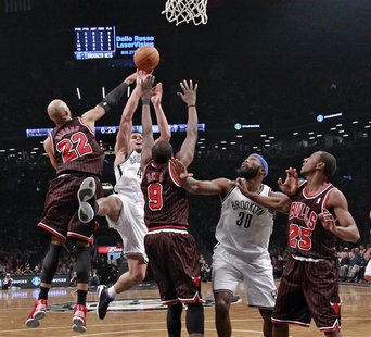 Brooklyn Nets forward Kris Humphries (43) shoots between Chicago Bulls forwards Taj Gibson (22) and Luol Deng (9) as Nets forward Reggie Eva Brooklyn Nets forward Kris Humphries (43) shoots between Chicago Bulls forwards Taj Gibson (22) and Luol Deng (9) as Nets forward Reggie Eva