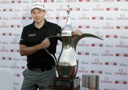 Stephen Gallacher of Scotland poses with the trophy at the 18th green after the fourth and final round of the Dubai Desert Classic at the Em Stephen Gallacher of Scotland poses with the trophy at the 18th green after the fourth and final round of the Dubai Desert Classic at the Em