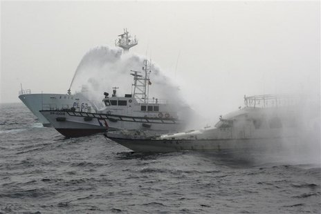 A Japan Coast Guard patrol ship (L) sprays water at a fishing boat (R) carrying Taiwanese activists onboard while it heads for the disputed A Japan Coast Guard patrol ship (L) sprays water at a fishing boat (R) carrying Taiwanese activists onboard while it heads for the disputed