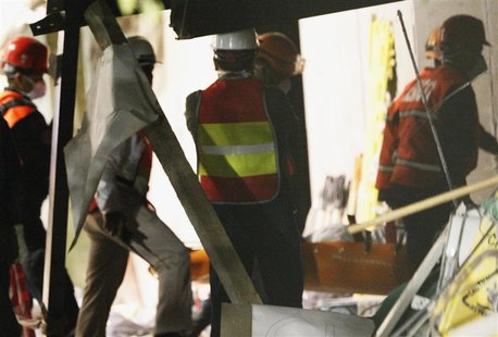 Rescue workers carry a stretcher with the body of the 36th victim at the site of an explosion at the headquarters of state-owned oil giant P Rescue workers carry a stretcher with the body of the 36th victim at the site of an explosion at the headquarters of state-owned oil giant P